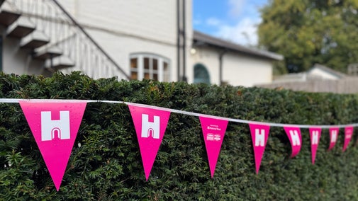 Pink and white Heritage Open Day bunting along a hedge at Polesden Lacey